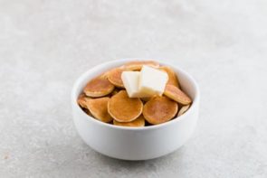 mini keto pancakes in a small bowl with butter on top