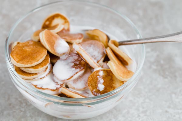 a bowl of mini pancake cereal with milk