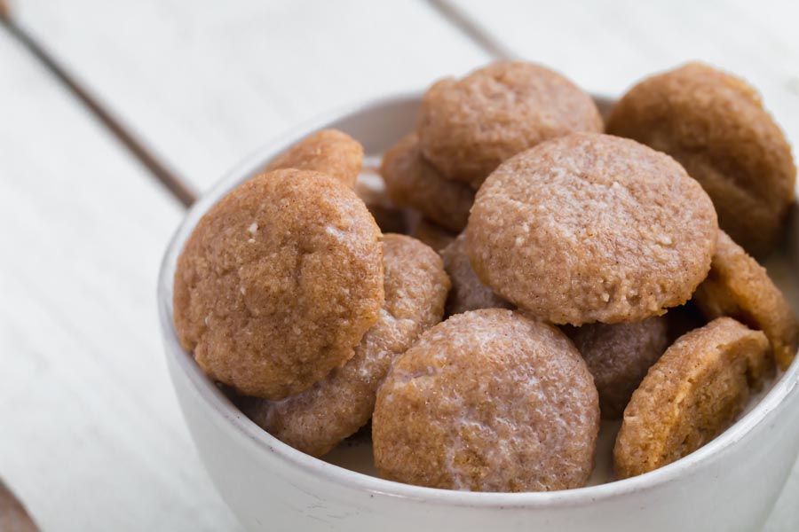 close up view of sugar free snickerdoodle cookies in a bowl with milk