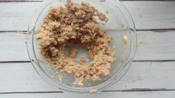 using a sifter to sift dry ingredients in a clear bowl