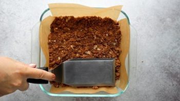 pressing down chocolate crust with a spatula