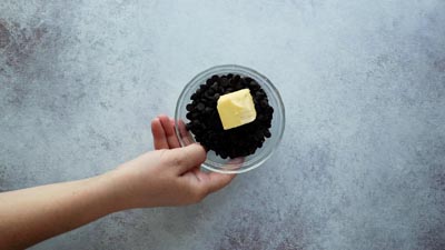 chocolate chips and a slab of butter in a small glass bowl