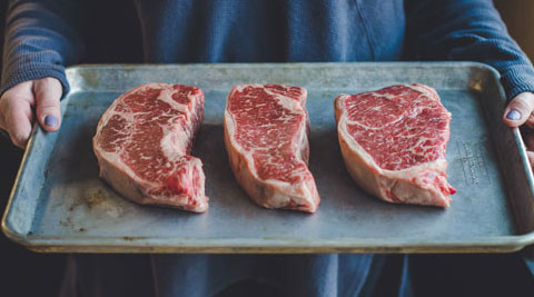 3 New York strip steaks on a tray