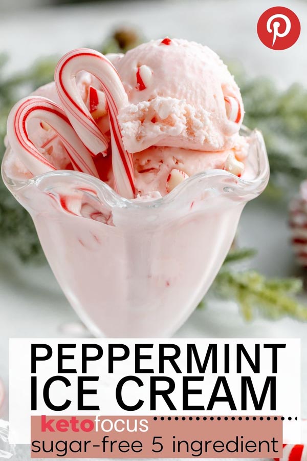 a glass sundae jar filled with pink peppermint ice cream with chunks of peppermint and candy canes