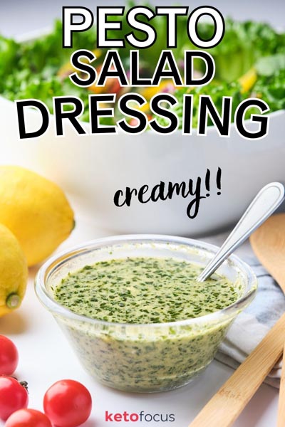 Creamy version of pesto dressing in a small bowl in front of a bowl of salad
