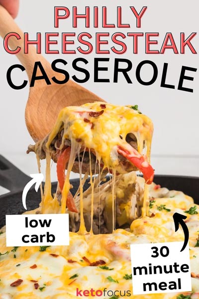 Pulling out a spoonful of casserole with cheese pulling as the spoon is lifted.