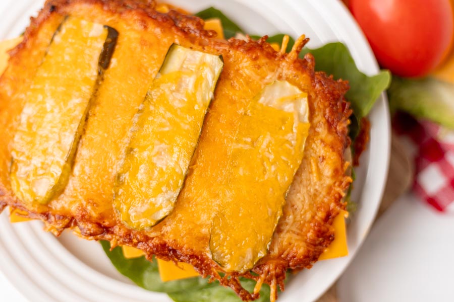 Overhead view of crispy cheese "bread" with pickle slices baked on top.