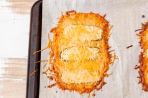 Freshly baked cheese and pickle "bread" cooling on a parchment-lined tray.