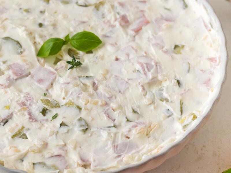 Close-up of creamy pickle wrap dip with pieces of ham and dill pickles mixed throughout.