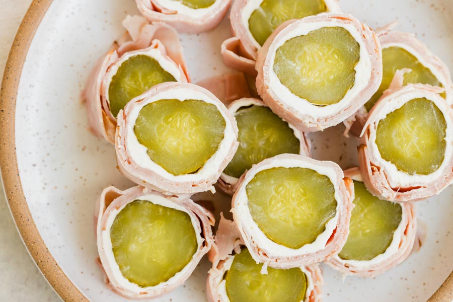 Overhead view of pickle roll-ups showing the bright green pickles and cream cheese filling.
