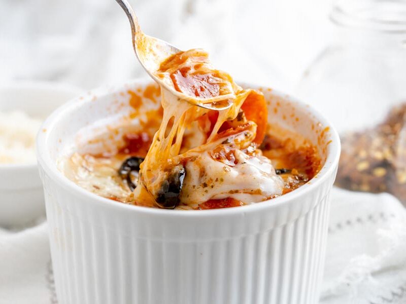 pulling out a spoonful of cheese and pepperoni