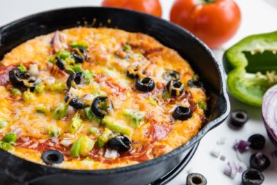 keto pizza dip in a cast iron skillet with supreme toppings