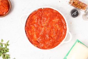 marinara spread over a meatloaf in a white dish