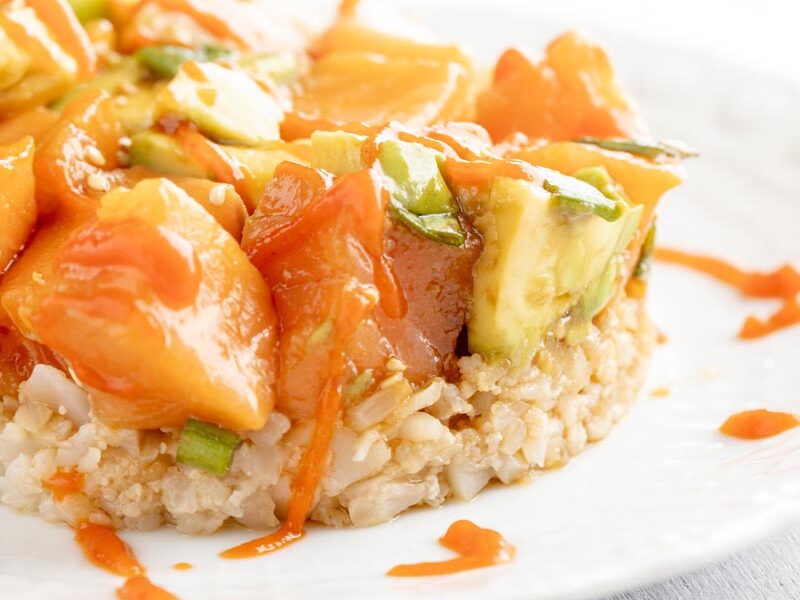 a plate with cauliflower rice and raw salmon over it