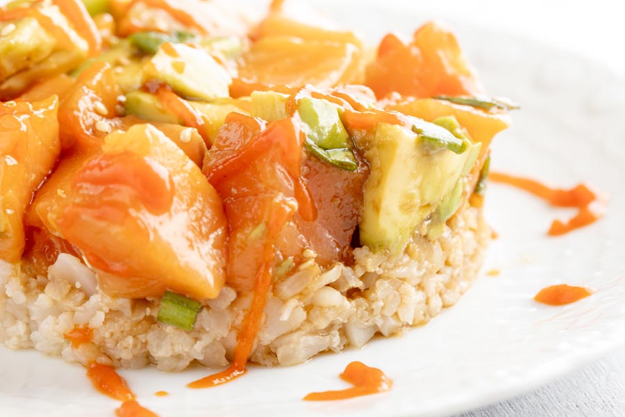a plate with cauliflower rice and raw salmon over it