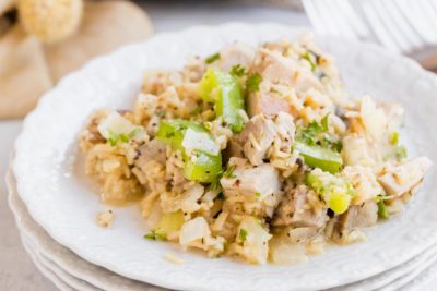 savory pork and rice mixed with cooked vegetables on a white plate