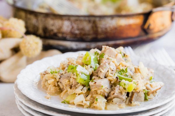 white plates stacked up with a pork and rice dinner on top