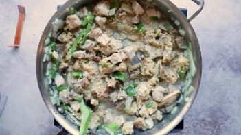 a skillet with pork, rice and vegetables cooked in it