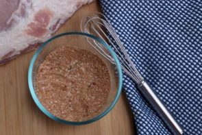 a small bowl with dry rub seasoning next to a small whisk