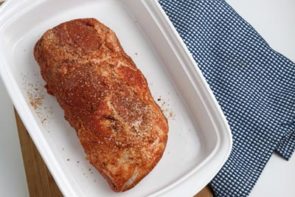 an uncooked pork loin in a baking casserole dish