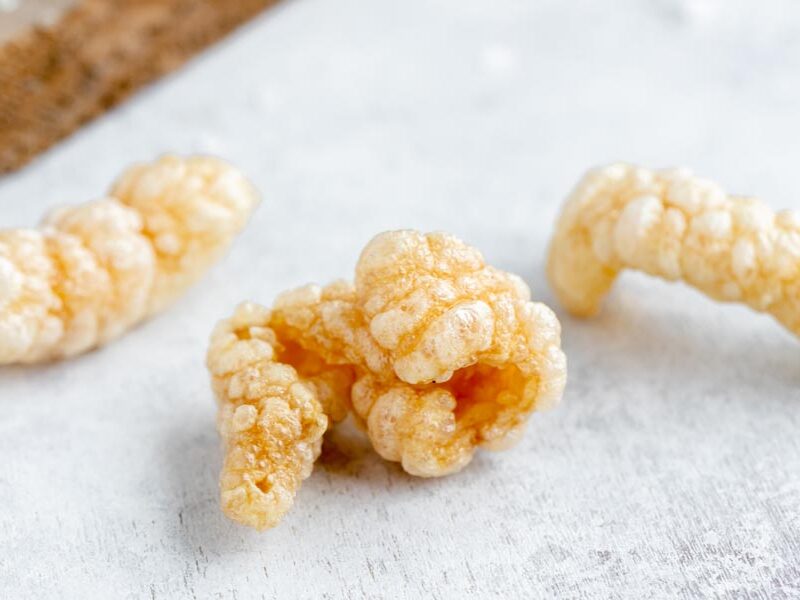 Close up of three pork rinds to show how light, airy and crispy they are.