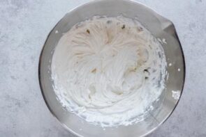 A stainless steel bowl with creamy cream cheese mixture inside.
