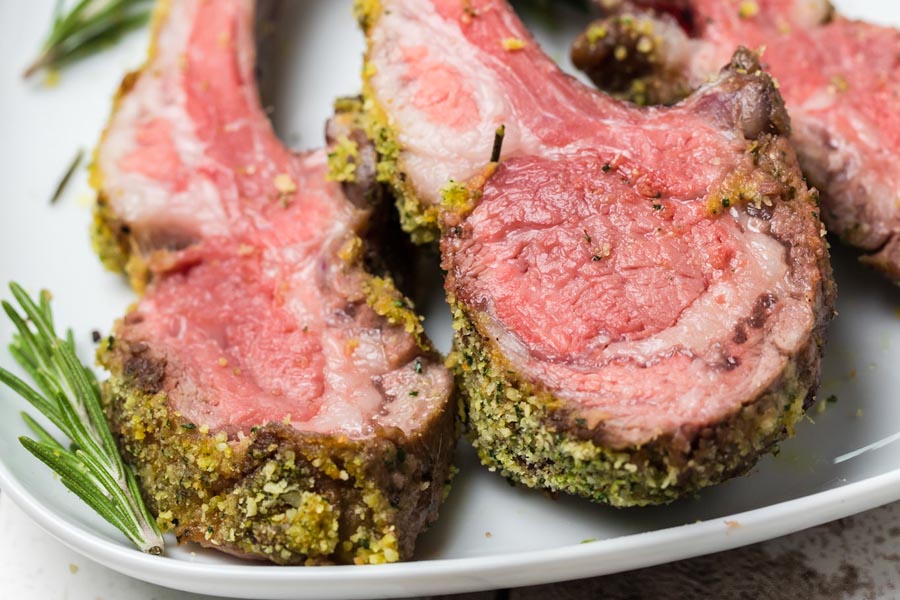 sliced rib meat on a plate with rosemary