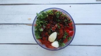 parsley, garlic and red peppers in a mini food chopper