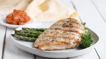 a grilled chicken breast on a plate with asparagus