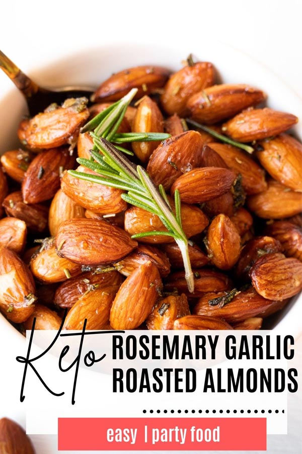 salted roasted almonds in a bowl with a rosemary sprig to top