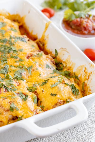 a baking dish with baked salsa chicken topped with cheese