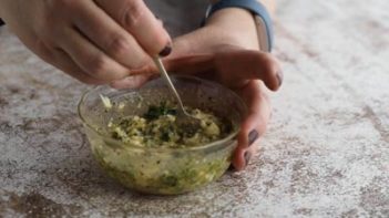 mixing butter garlic and parsley mixture with a spoon