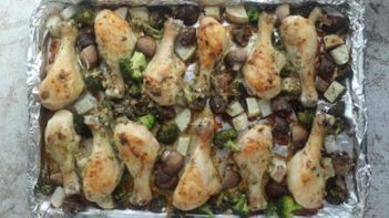 a large tray with cooked chicken and vegetables on it