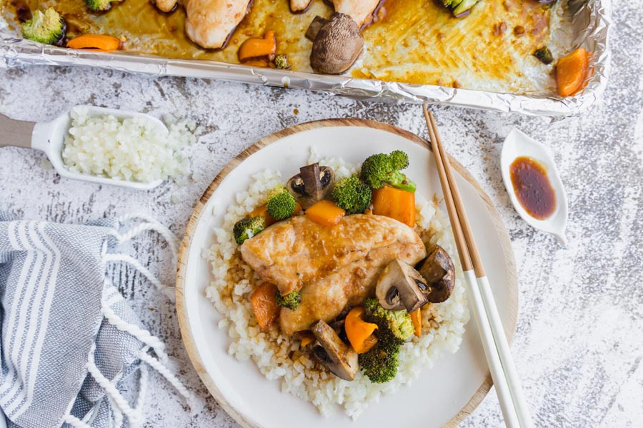 chicken teriyaki on a plate over rice with chopsticks and sauce