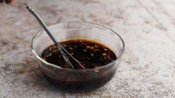 a whisk sits inside a bowl with a teriyaki sauce in it