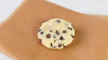 single cookie dough ball on a piece of parchment paper