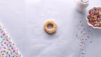 An unbaked donut with a large circle hole.