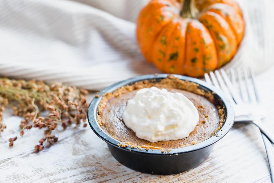 small pumpkin pie topped with whipped cream