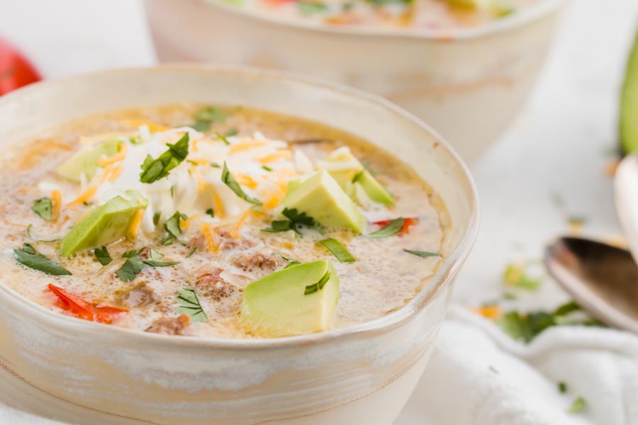 two bowls of creamy keto ground beef taco soup with spoons