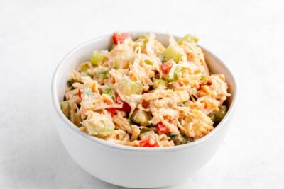 Creamy Southwest chicken salad with celery and red bell pepper in a white bowl.