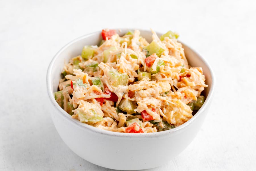 Creamy Southwest chicken salad with celery and red bell pepper in a white bowl.