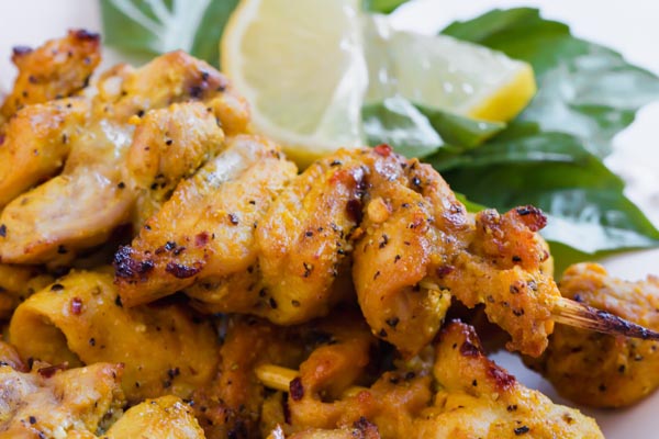 chicken kebabs with lemon in background