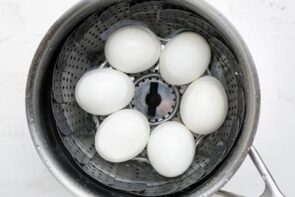 Six eggs cooking in a pot.