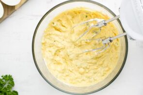 Yolk mixture creamed together in a bowl with electric mixer inside the filling.