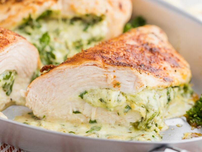 a jjuicy chicken breast cut in half with a cheesy spinach mixture inside