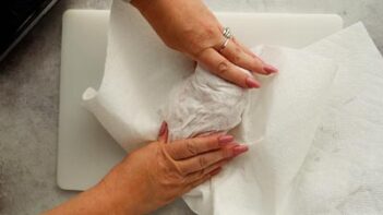 patting chicken dry with a paper towel