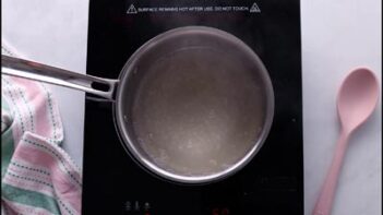 A saucepan of agar agar mixture being heated on the stovetop until dissolved.