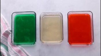 Three containers filled with green, clear, and red colored agar gelatin cooling to set.