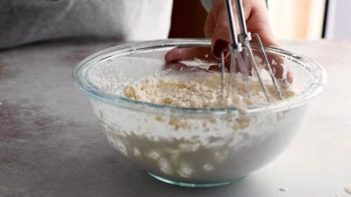 mixing cream cheese filling with an electric mixer