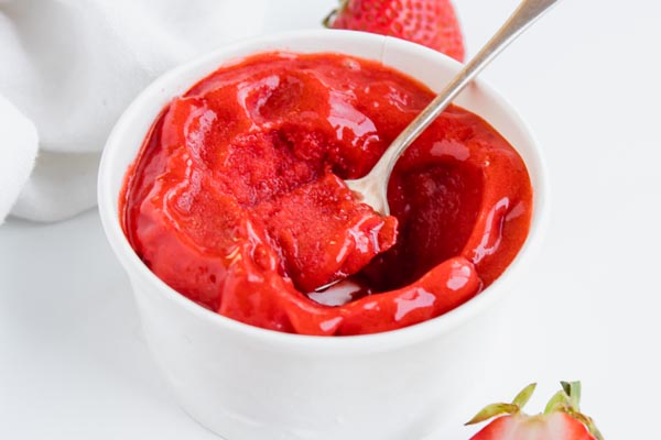 digging into a pint of strawberry sorbet with a spoon